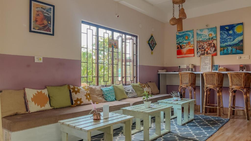 a living room with two tables and a couch at Thikana by Mulaqat in Siliguri