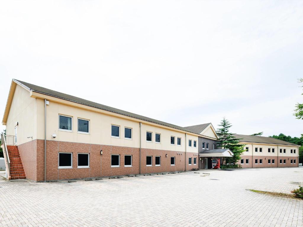 een groot bakstenen gebouw met veel ramen bij Comfort Inn Karuizawa in Karuizawa