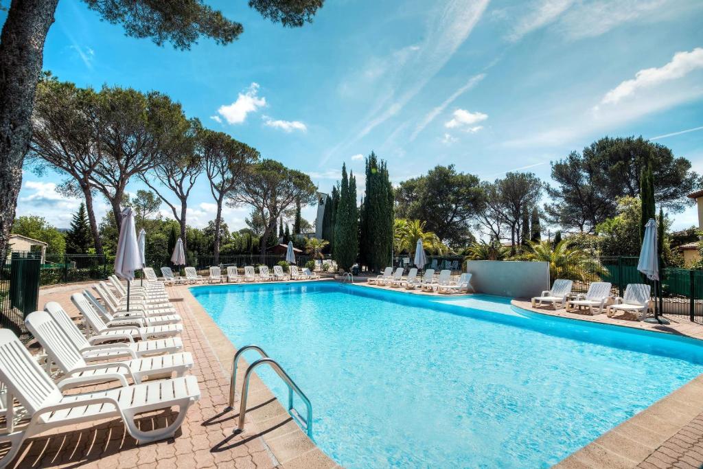 a pool with chaise lounge chairs and a swimming pool at Comfort Aparthotel Frejus La Tour de Mare in Fréjus