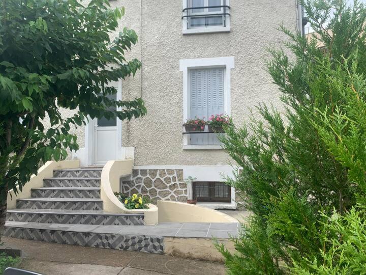 a building with stairs leading up to a building with a window at La Grande Maison Paris Sud in Vitry-sur-Seine