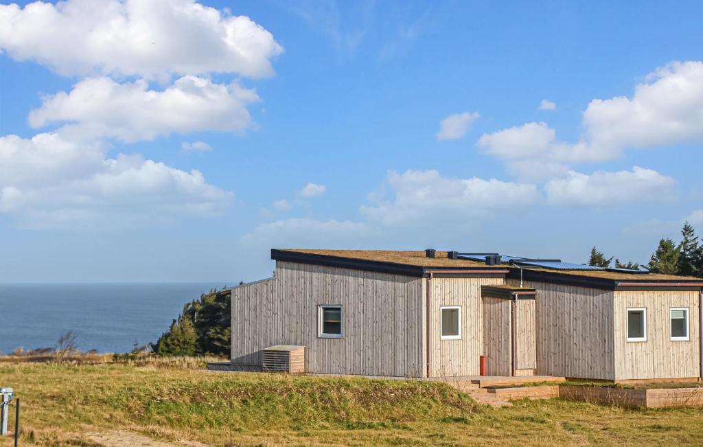 a house on a hill with the ocean in the background at 5 Bedroom Amazing Home In Hanstholm in Pugdal