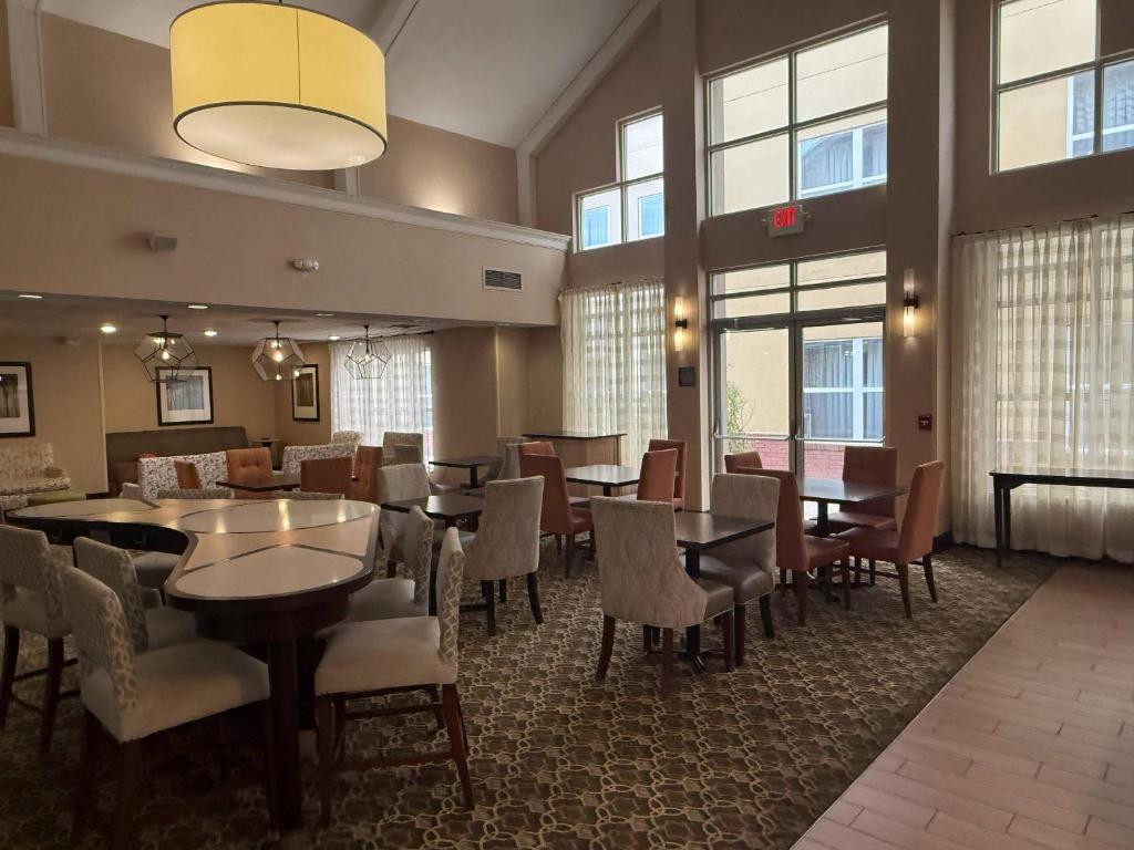 a dining room with tables and chairs and windows at MainStay Suites in Grand Rapids
