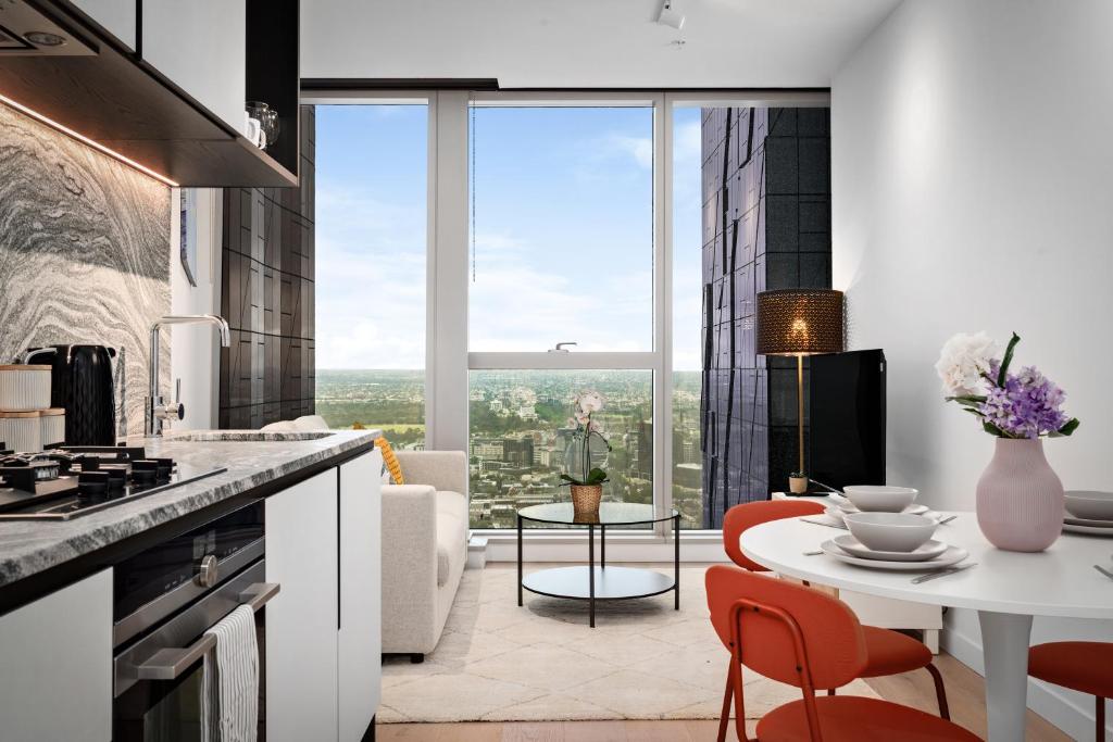 a kitchen and living room with a table and chairs at Brand New Luxury Stay with Garden View Same Tower as Ritz Carlton in Melbourne