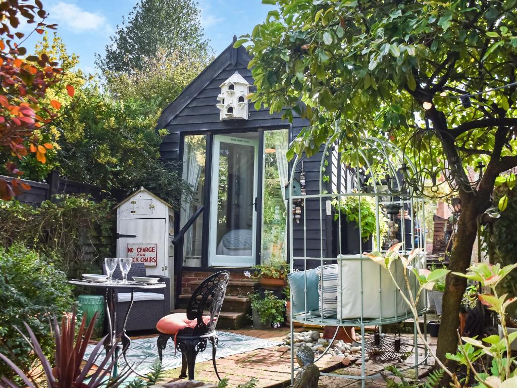 WangfordにあるAlec Hill's Bakehouseの庭にあるテーブルと椅子のある小さな家