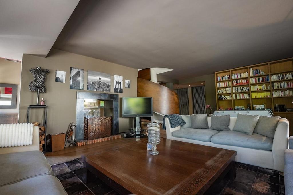 ein Wohnzimmer mit Sofa und Tisch in der Unterkunft La Villa du Cinéma 