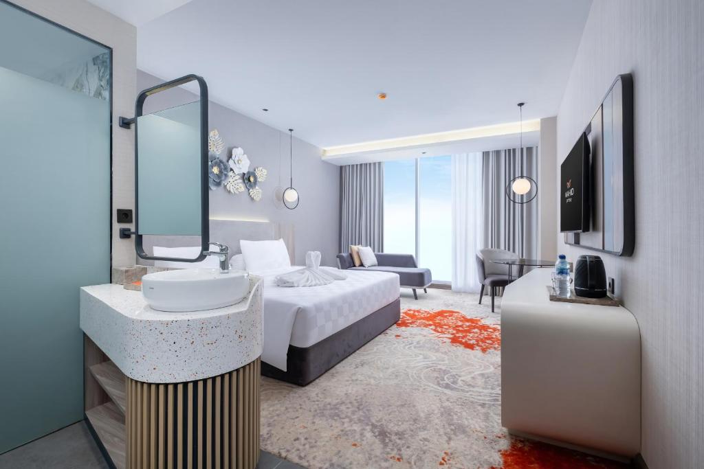 a bedroom with a bed and a sink and a mirror at Wahid Prime Hotel Salatiga in Salatiga