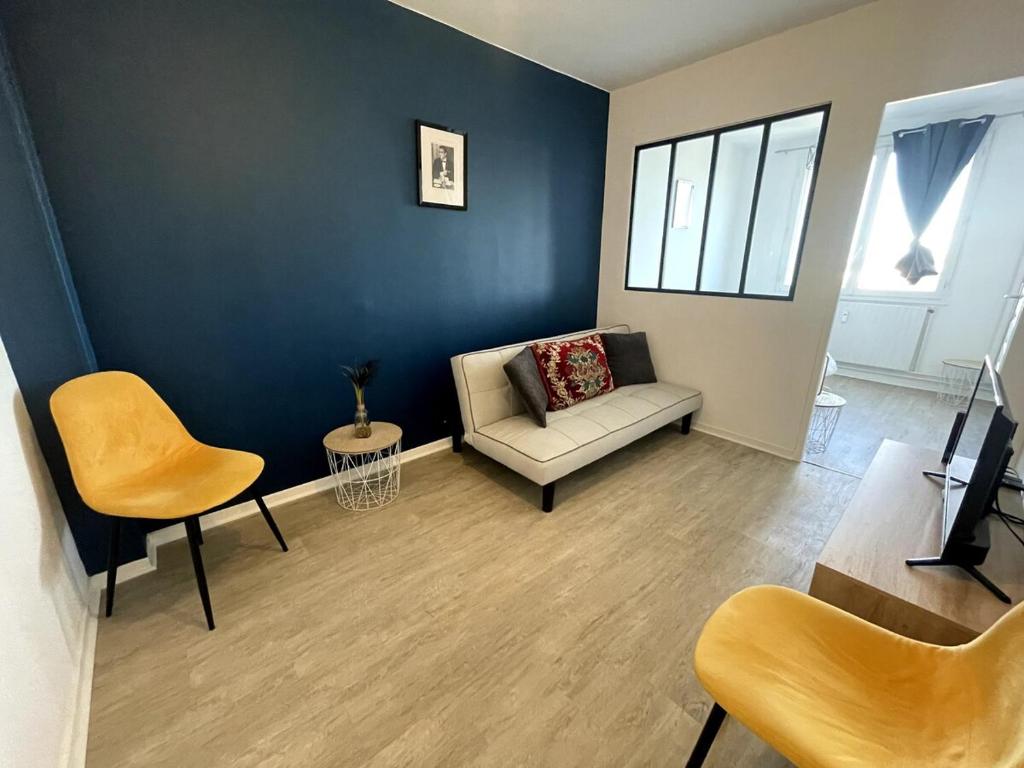 a living room with a couch and a chair at Leo Lagrange in Champforgeuil