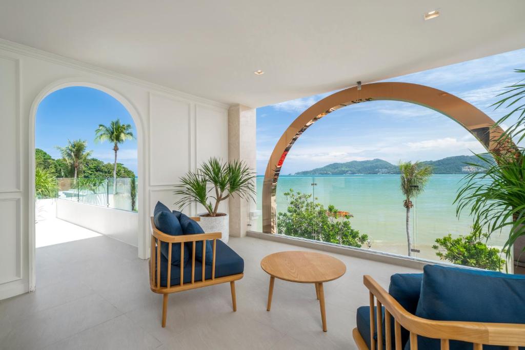 an arched window in a living room with a view of the ocean at The Cyan at Patong Hotel in Patong Beach