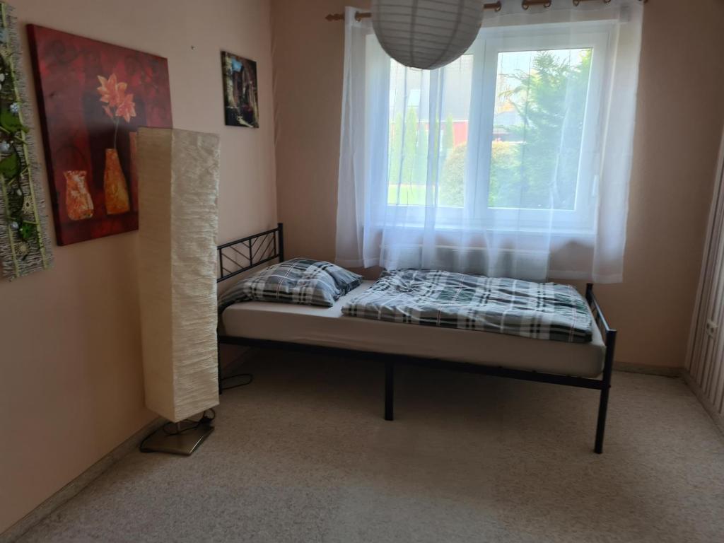 ein kleines Bett in einem Zimmer mit Fenster in der Unterkunft Zimmer in Ferienwohnung Bühler in Karsdorf