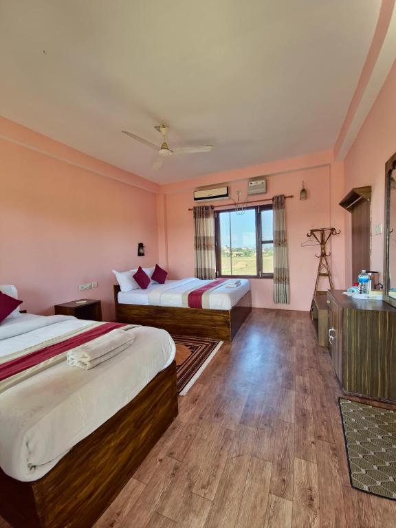 um quarto de hotel com duas camas e uma pia em Hotel Tree Tops em Sauraha