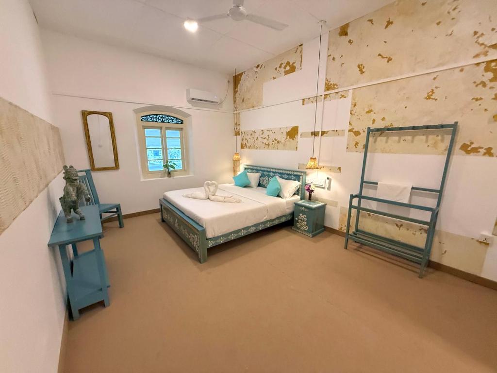 a bedroom with a bed and a mirror on the wall at Sudu Colonial House 1929 in Ambalangoda