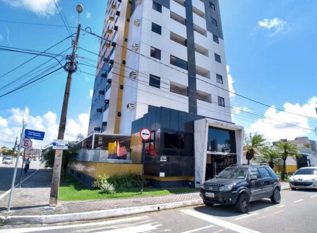 a car parked in front of a tall building at Apartamento em João Pessoa in João Pessoa