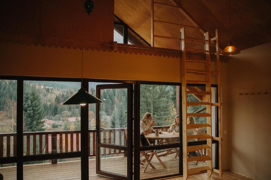 two people sitting at a table on the balcony of a house at Ліс Снів in Tatariv