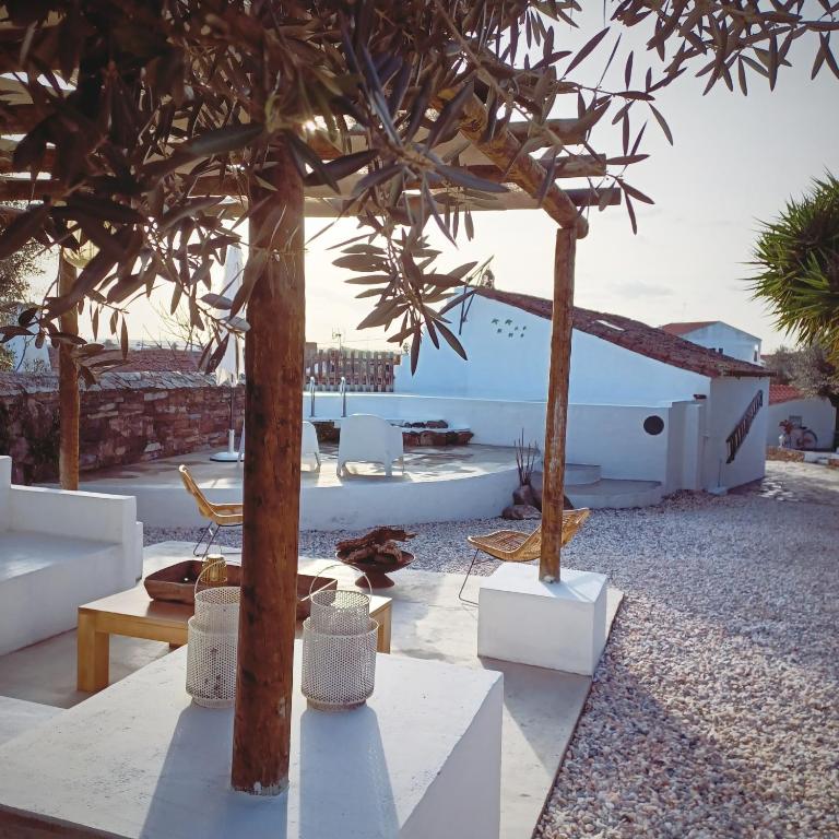 a patio with a table and chairs and a tree at Villa Oliva São Pedro in São Pedro do Corval