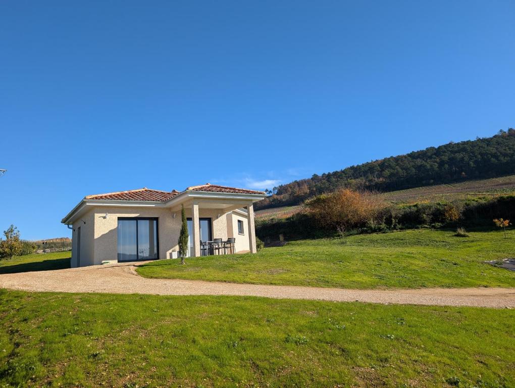 een klein huis op een heuvel met een onverharde weg bij L'échappée Bourguignonne in La Roche-Vineuse