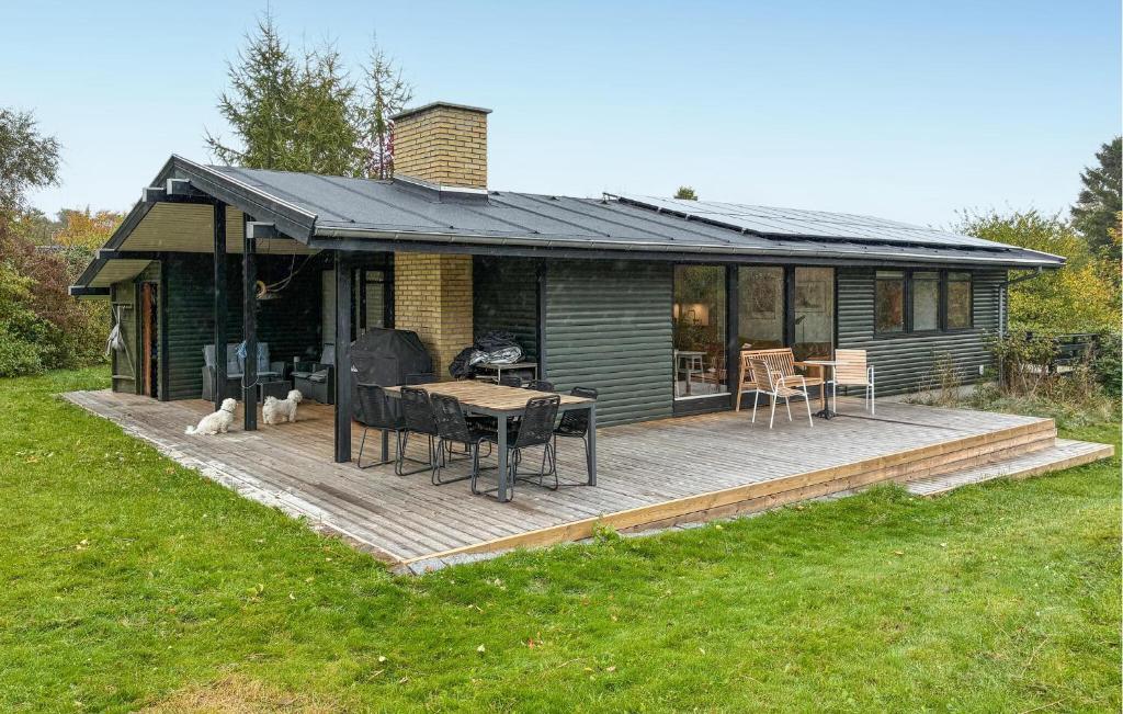 VejbyにあるAmazing Home In Vejby With Wifiのデッキ(テーブル、椅子付)が備わる家