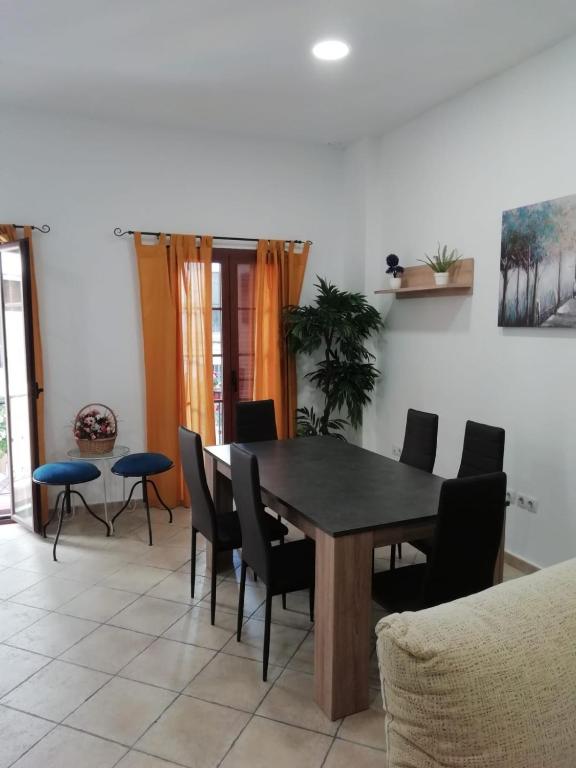 a dining room with a black table and chairs at Apartamento centro ciudad in Algeciras