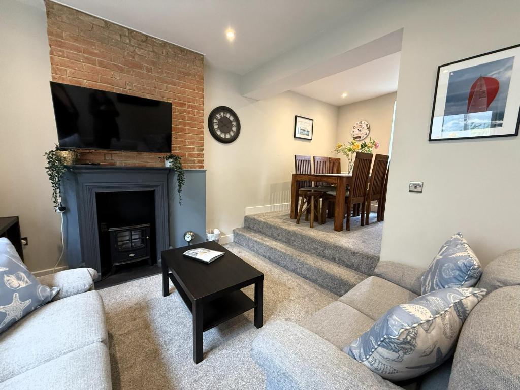 een woonkamer met een bank en een open haard bij Castle Cottage - Central seaside town in Ryde