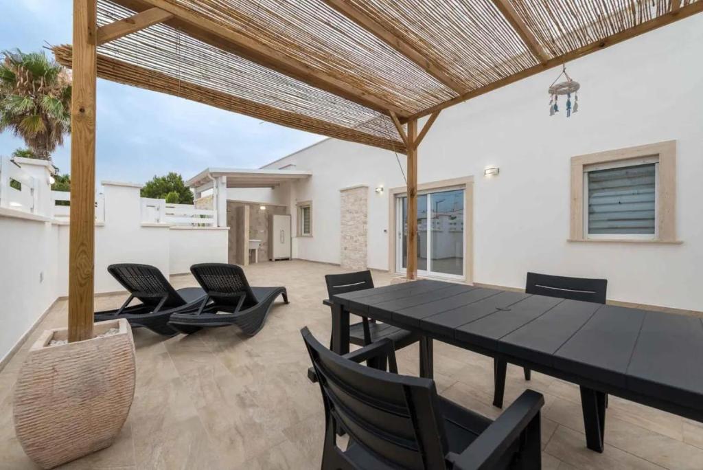 a patio with a black table and chairs at Fichi d'India Appartamenti in San Pietro in Bevagna