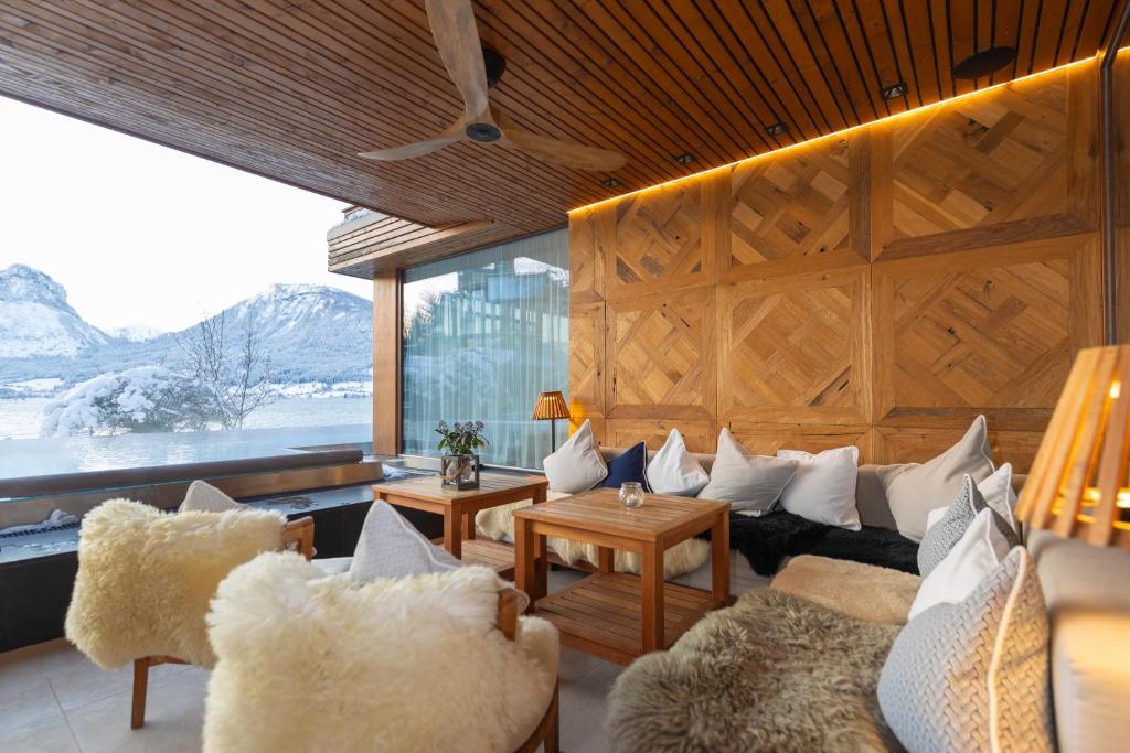 een woonkamer met een bank en een groot raam bij Hotel Seevilla Wolfgangsee in St. Wolfgang