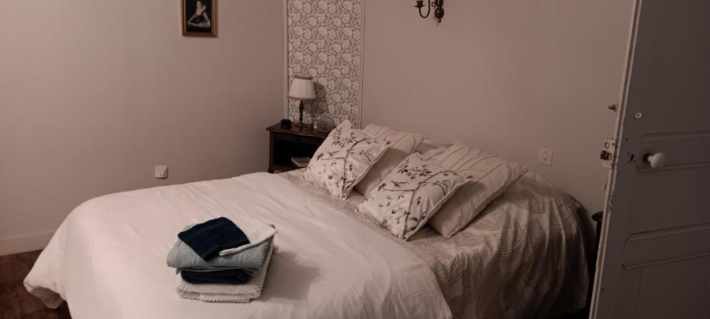 a bedroom with a bed with two towels on it at Le domaine du Champ Han in Saint-Hilaire-du-Harcouët