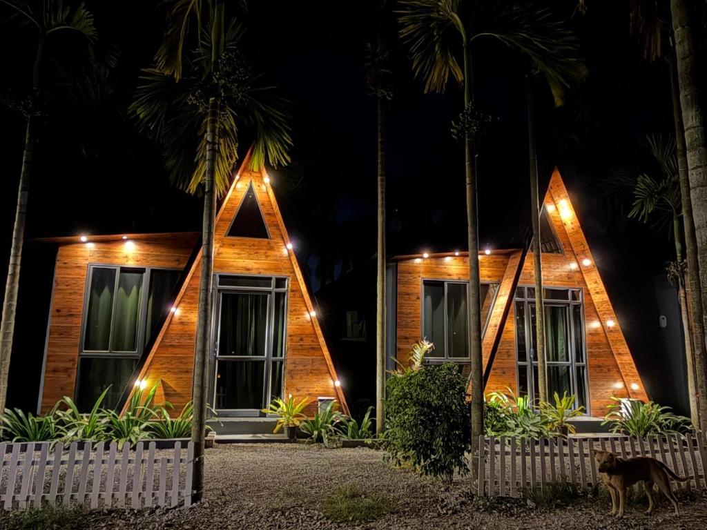 een houten huis met 's nachts verlichting bij Raghavs Retreat Chikmaglur in Chikmagalūr