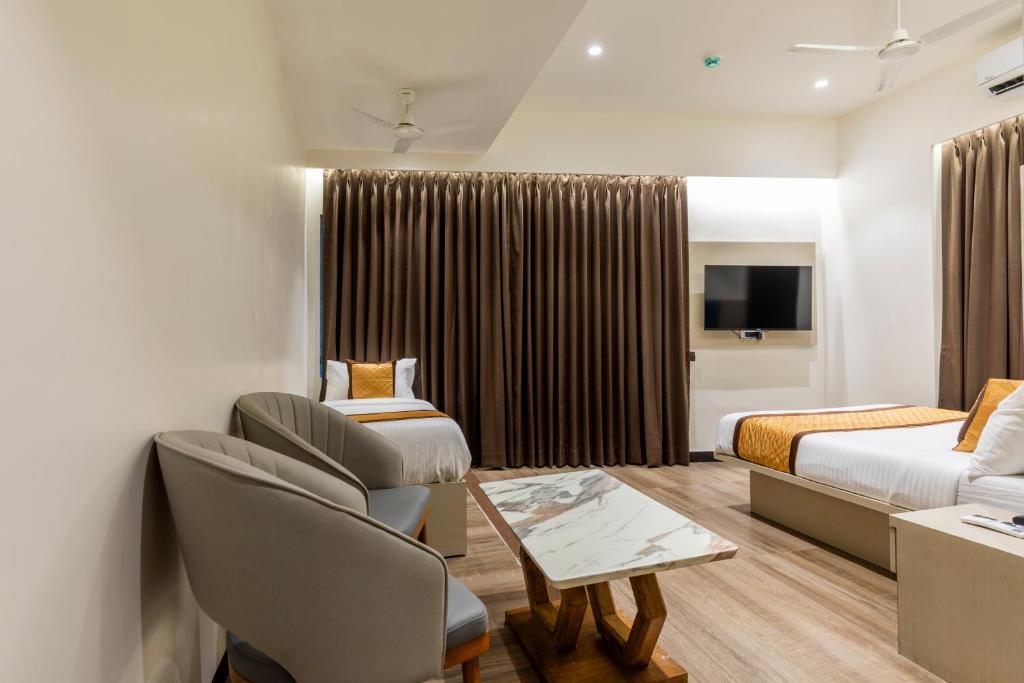 a hotel room with a bed and a couch at Hotel Mint in Thane