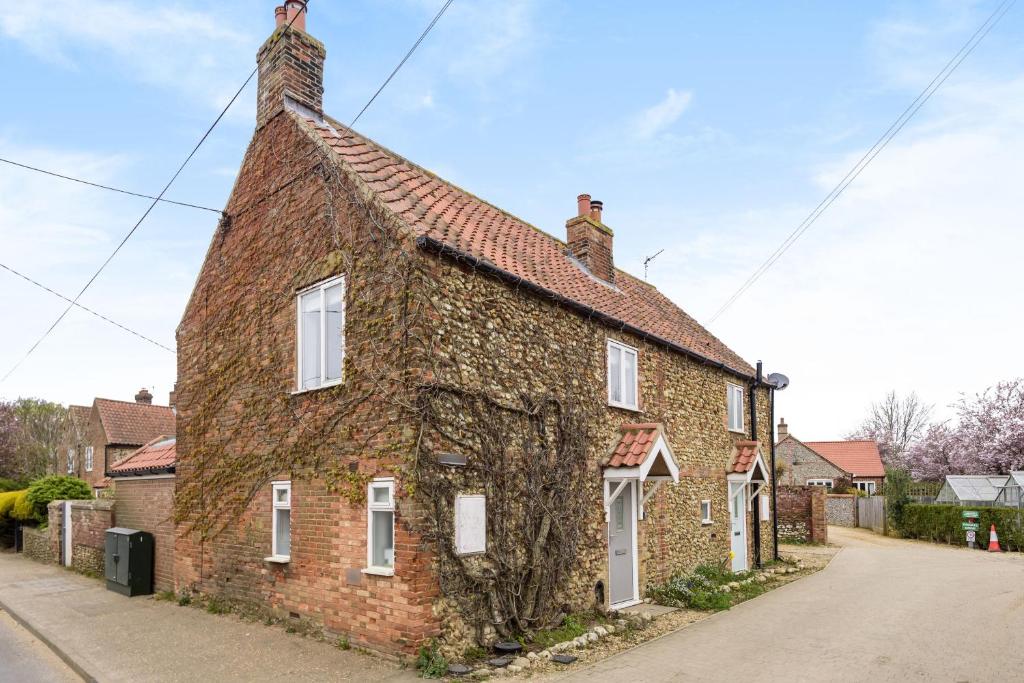 ein altes Backsteinhaus mit weißen Fenstern auf einer Straße in der Unterkunft 1 Crarves in Docking