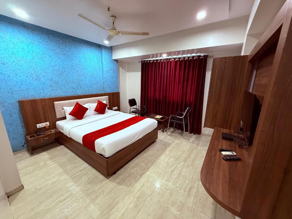 a bedroom with a large bed with red pillows at Hotel Arya Residency Rabale in Airoli