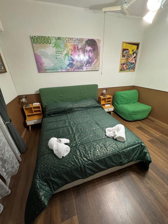 een slaapkamer met een groen bed en 2 handdoeken bij B&B Amores in Sulmona