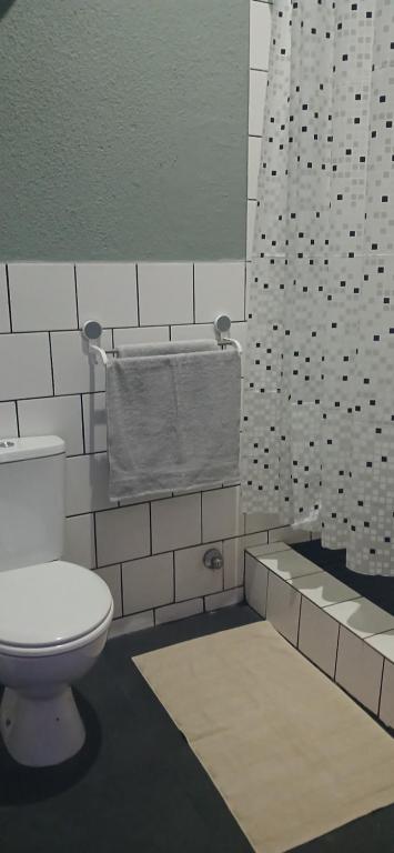 a bathroom with a toilet and a towel at Stylish Bachelor with Oak Floors & View in Johannesburg