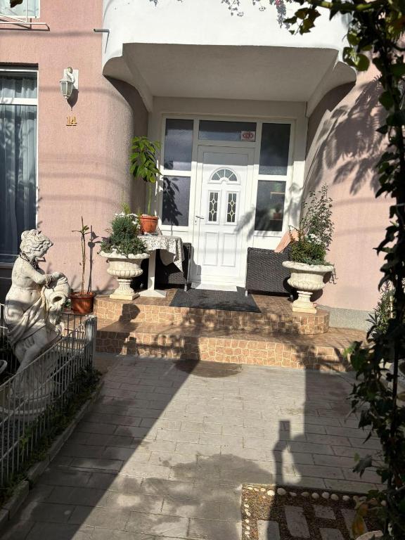 a front door of a pink house with potted plants at Casa Ana in Eforie Nord
