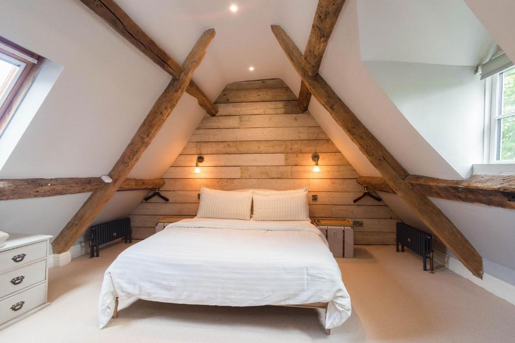 Bett in einem Schlafzimmer im Dachgeschoss mit Holzbalken in der Unterkunft Cotswold Cottage- Central Witney in Witney