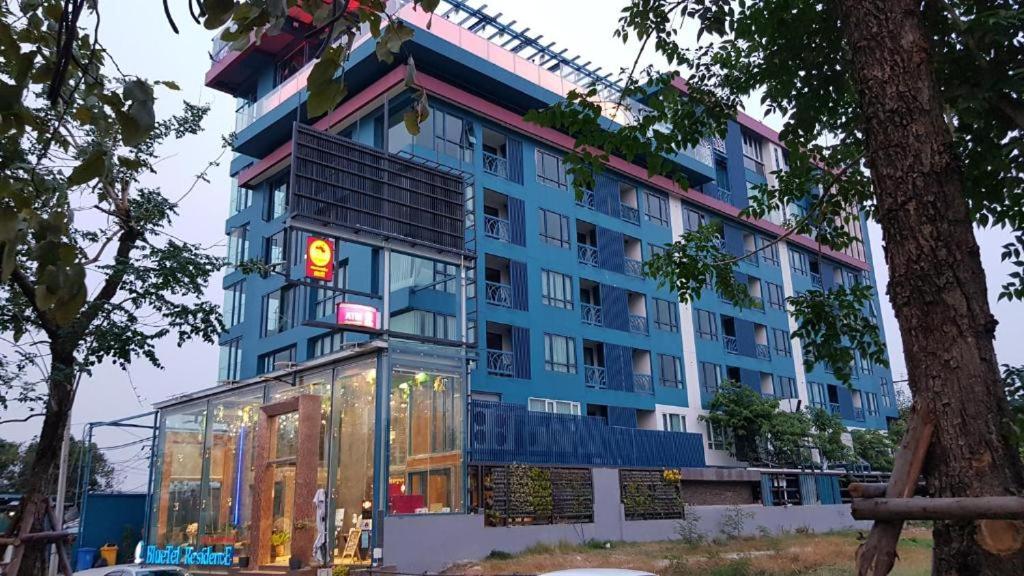 a blue building with a traffic light in front of it at BlueTel Re'sidencE Bangkok IMPACT บลูเทล เรซิดองส์ กรุงเทพ อิมแพค in Nonthaburi