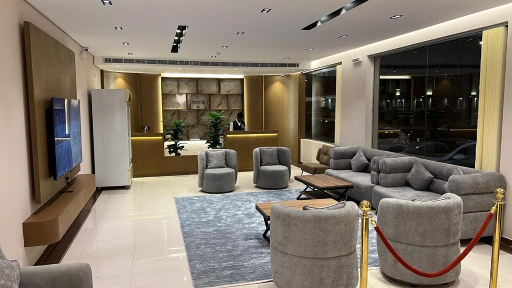a lobby with couches and chairs and a television at اجنحة دانة DANAT Suites الرياض حي اليرموك in Riyadh