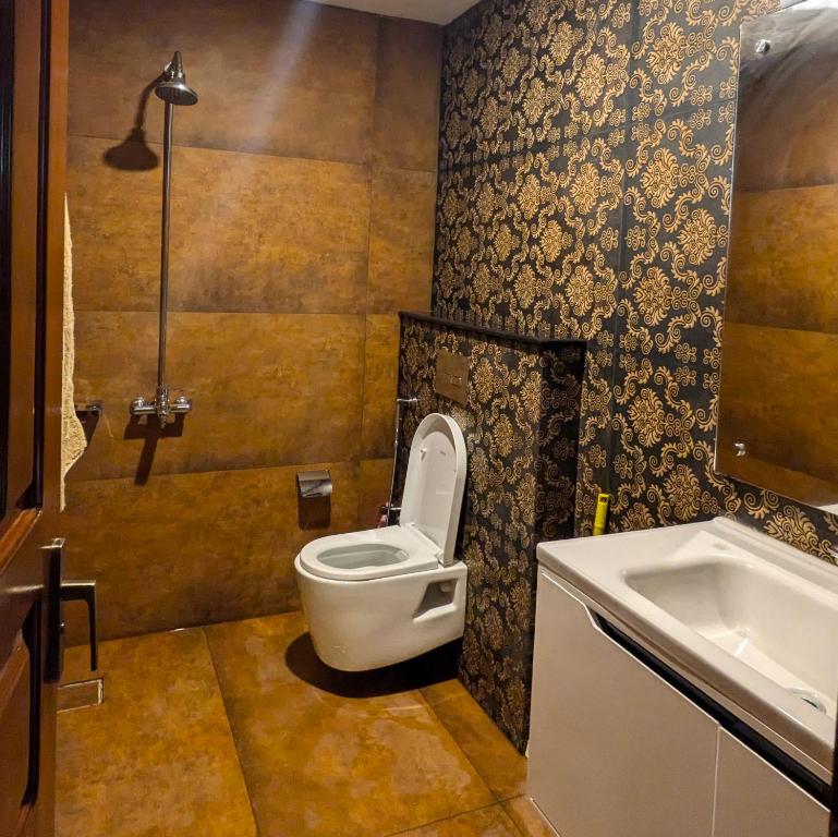 a bathroom with a toilet and a sink at AlFalah Guest House in Murree