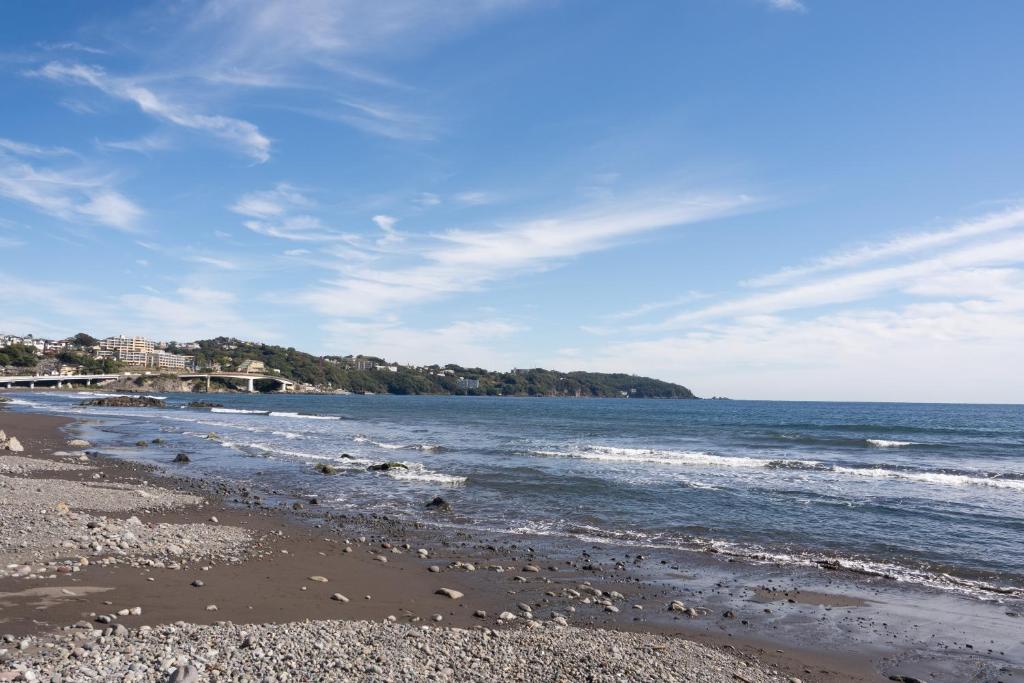 una playa con rocas y el océano en un día soleado en ＳｅａＳａｉｄｅＨｏｕｓｅ湯河原, en Yugawara