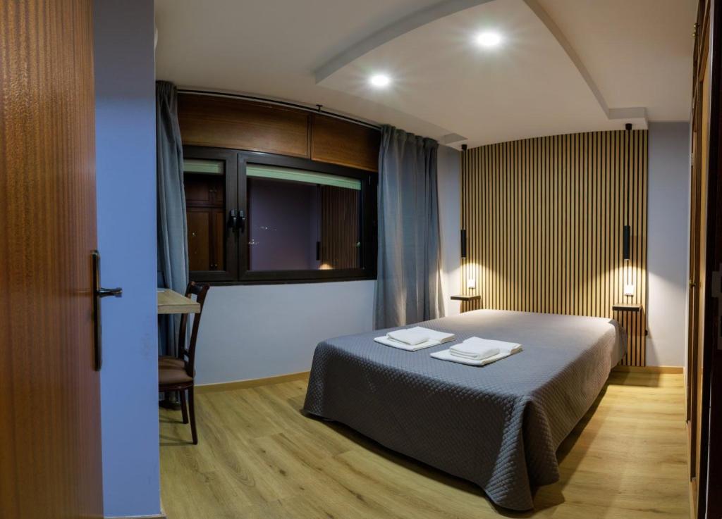 a bedroom with a bed with two towels on it at São Roque Suites in Bragança