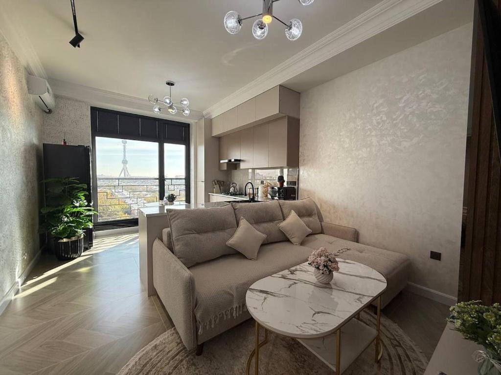 a living room with a couch and a table at Modern spaces 12 in Yunusobod