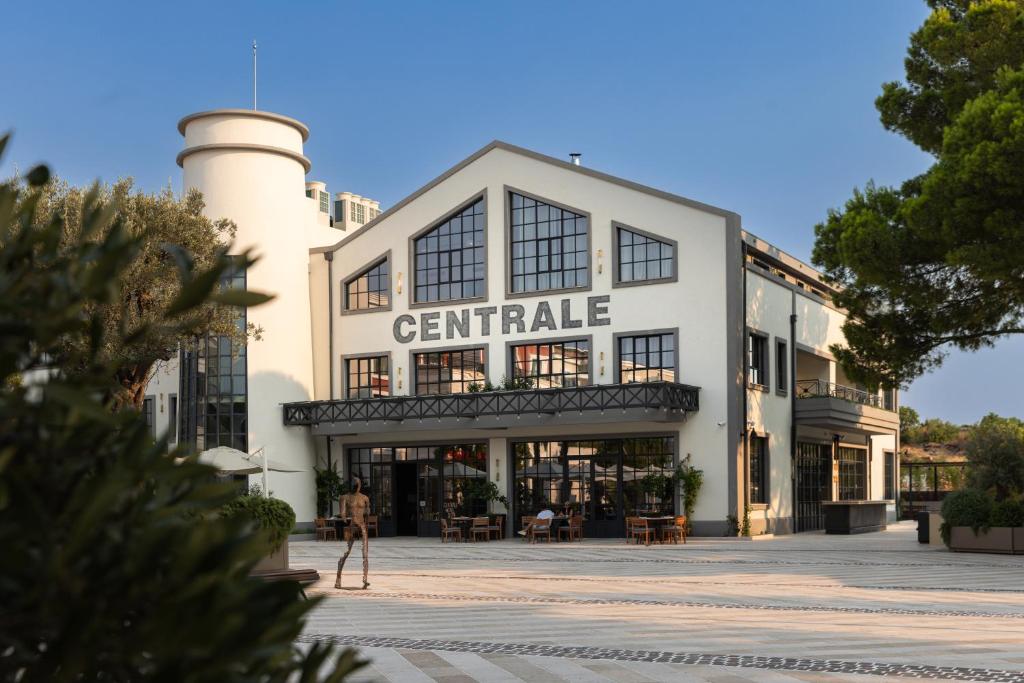 a white building with a tower on top of it at Centrale Lustica Bay by Angsana in Radovići