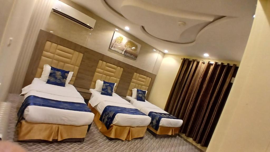 a hotel room with two beds with blue pillows at لانا العلا شقق مفروشة Lana Alula in AlUla