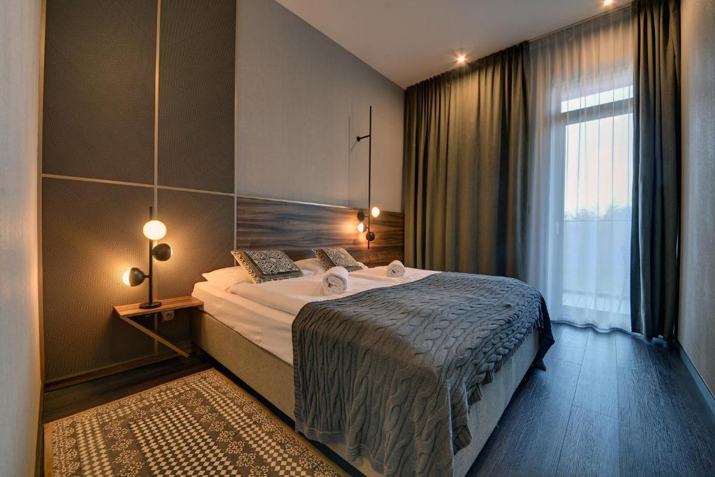 a bedroom with a large bed and a window at RentPlanet - Apartamenty Karkonoskie in Sosnówka