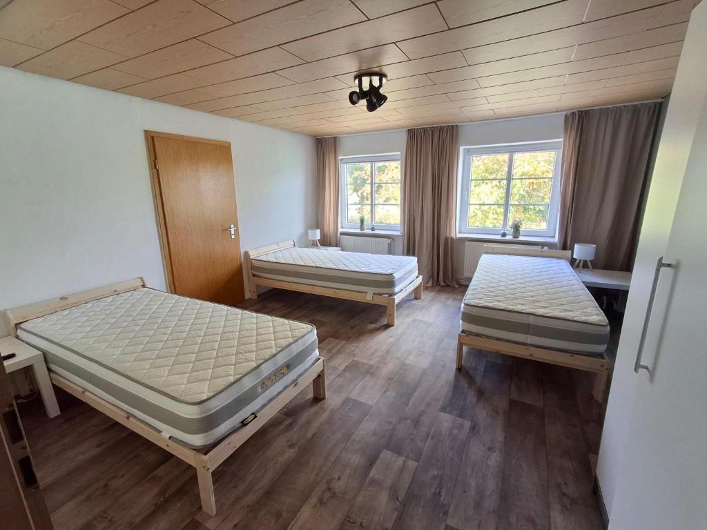 a room with two beds and two windows at Monteurwohung Nettelsee in Nettelsee