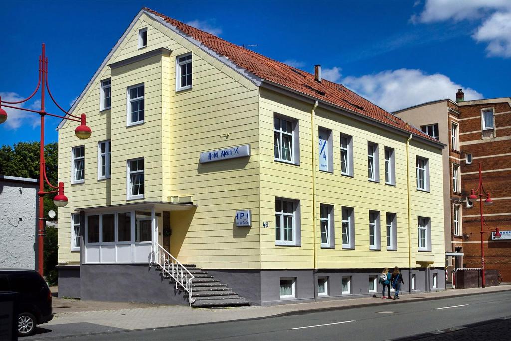 żółty budynek po stronie ulicy w obiekcie Hotel Neun 3/4 w mieście Celle