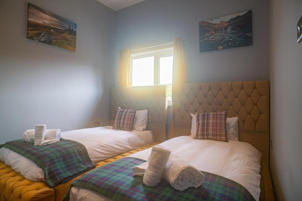 zwei Einzelbetten in einem Zimmer mit Fenster in der Unterkunft Seaview Cottage Schoolhouse 2 in Carbost