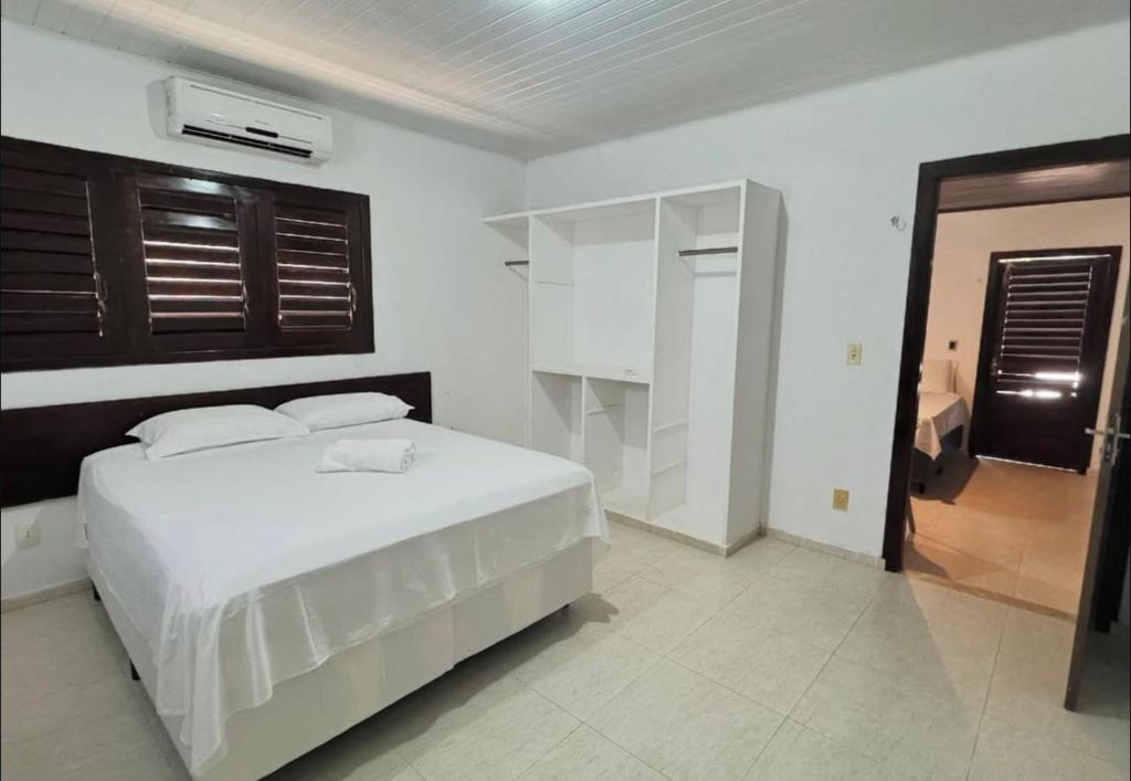 a white bedroom with a bed and a window at Pousada Solar de Maria e Hostel in Baixa de São Francisco