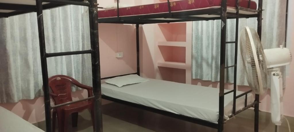 a bedroom with two bunk beds and a chair at Backpackers' Haven in Guwahati