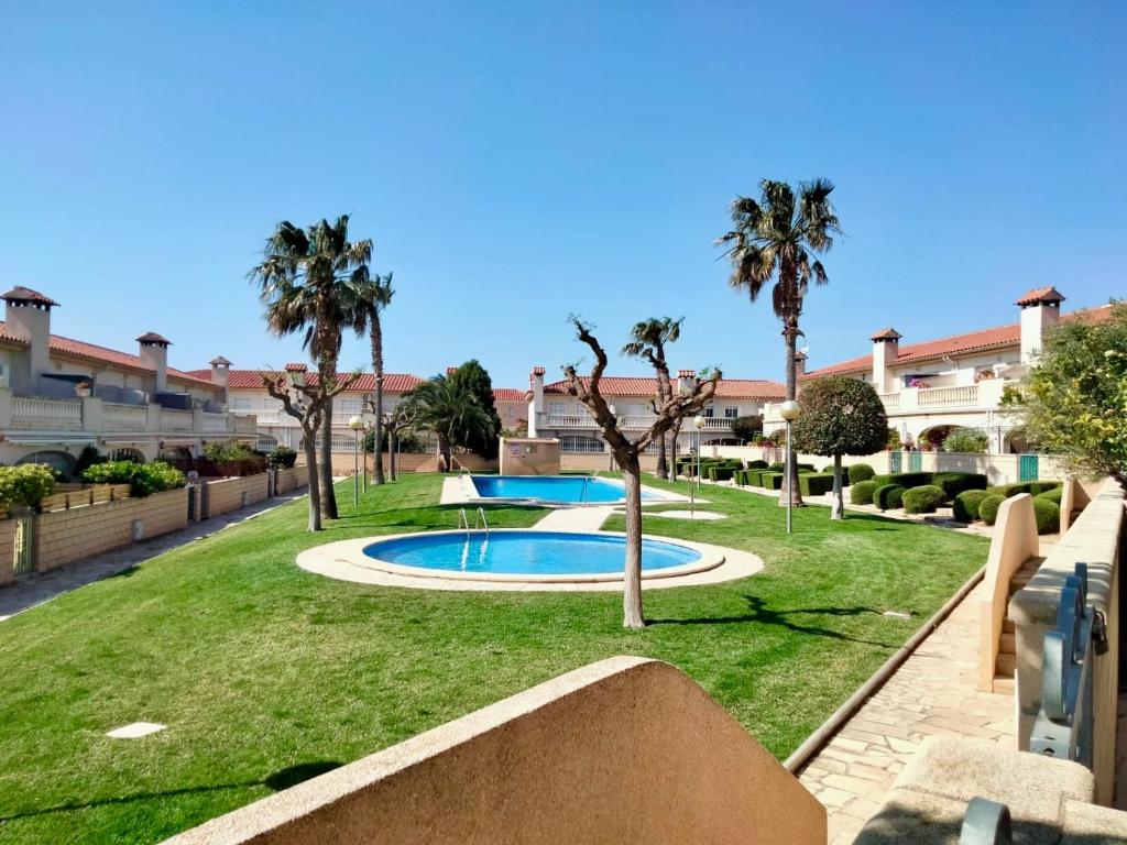 a yard with a swimming pool and palm trees at casa Palm Beach in Montroig