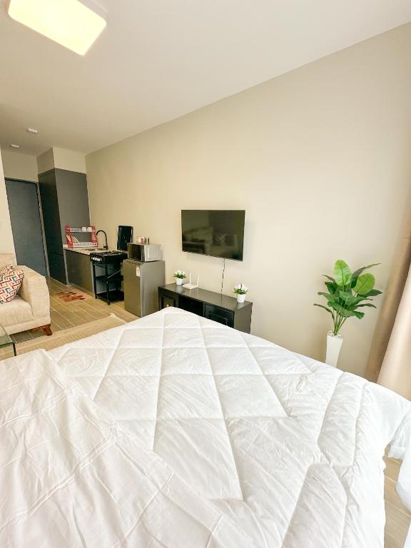a bedroom with a large white bed in a room at Cozystays by Vee Near JKIA in Nairobi