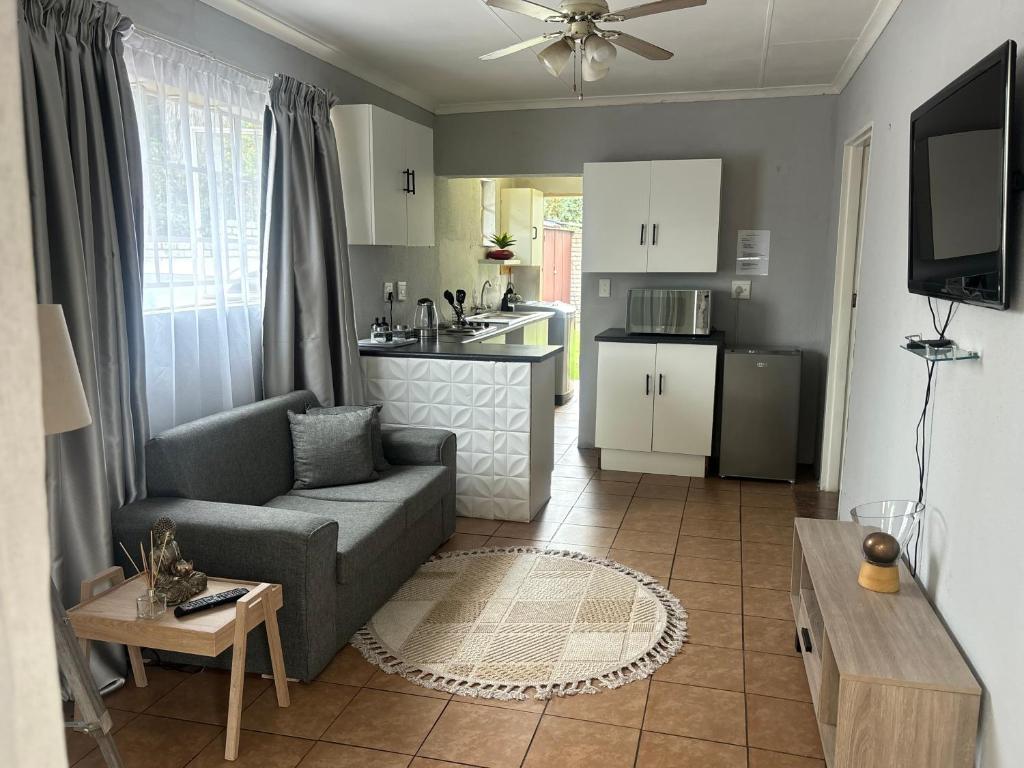 a living room with a couch and a kitchen at Tana's flat in Brakpan